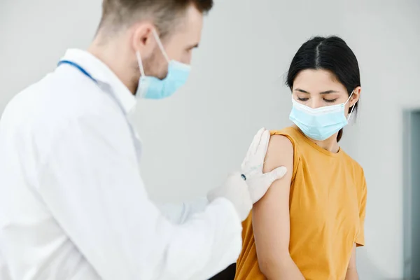 Omtänksam läkare injicerar covid-19 vaccin i kvinnliga patienter axelvaccination — Stockfoto