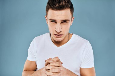 duygusal hoşnutsuz adam beyaz tişört mavi arka plan kırptı