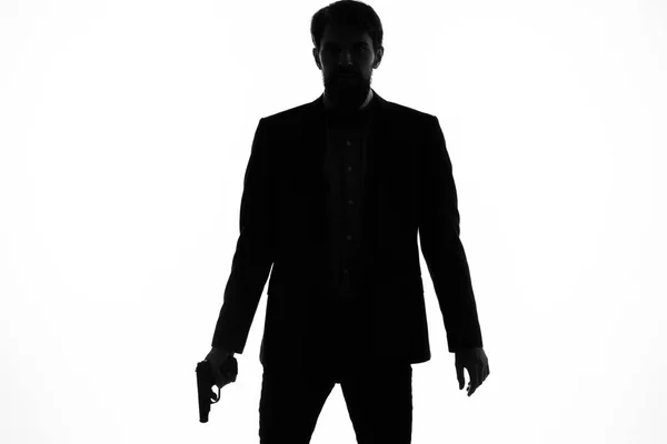 Shadow of a man with a gun in his hands aiming detective crime light background — Stock Photo, Image
