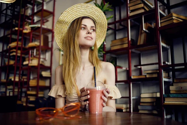 戴着帽子的漂亮女人在咖啡馆度假时喝果汁 — 图库照片