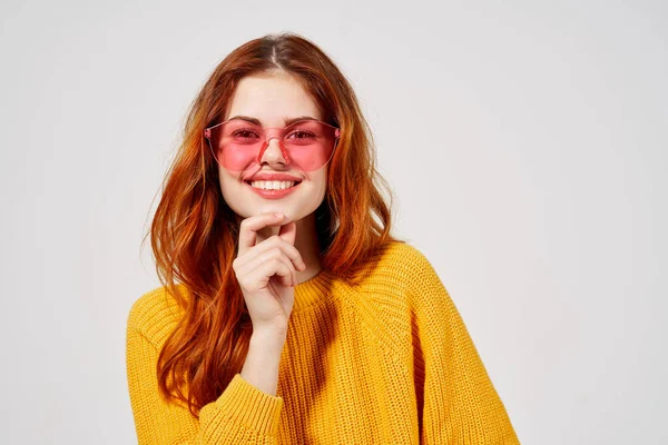 Jolie jeune femme en pull jaune et jeans lunettes roses posant — Photo