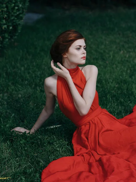 Mujer de lujo en rojo atractivo vestido verde hierba decoración de ocio —  Fotos de Stock