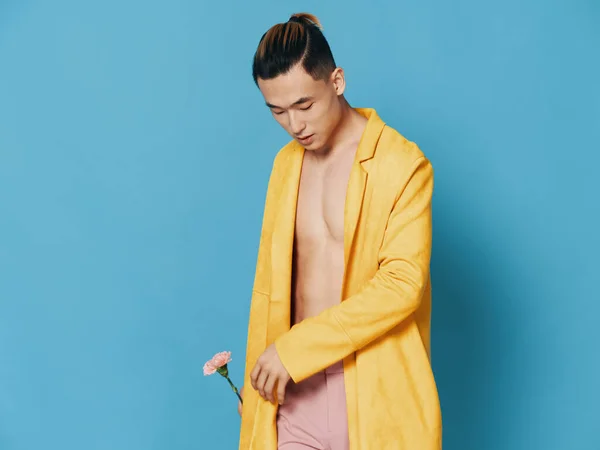 Ázsiai fickó sárga kabátban, virággal és meztelen törzzsel. — Stock Fotó