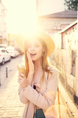 Sokakta bekleyen güzel bir kadın. Elinde dondurmayla şehirde dolaşıyor.