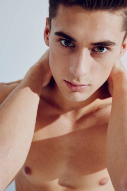 Yakışıklı, esmer, kaslı, kolları çıplak bir adam.