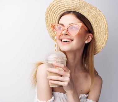 Yazlık şapkalı neşeli güzel kadın eğlence içkisi içiyor.