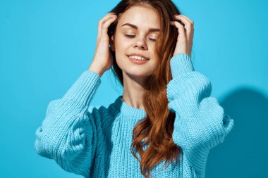 Mavi süveterli güzel kadın gülüşü mavi arkaplanı kırpıyordu.