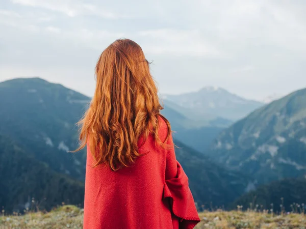 한 여자가 자연 속의 산들을 바라보며 어깨에 붉은 반점을 달고 있습니다 — 스톡 사진