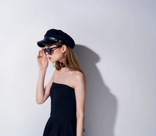Mujer en vestido negro gafas oscuras estudio lujoso fondo claro — Foto de Stock