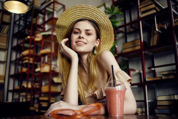 戴着帽子的漂亮女人在咖啡馆度假时喝果汁 — 图库照片