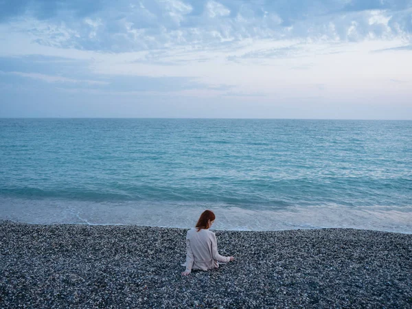 Женщина путешественник у океана на пляже и море в фоновых облаках — стоковое фото