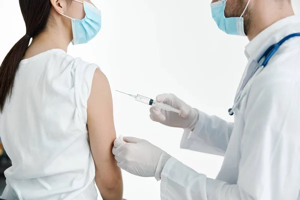 Läkare i vit rock injicera en kvinna axel vaccinationshandskar — Stockfoto