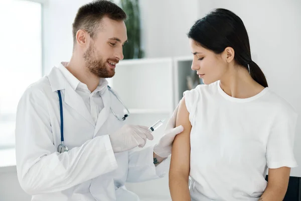 Läkare på sjukhus som ger injektion till kvinnliga patientvacciner skyddshandskar — Stockfoto