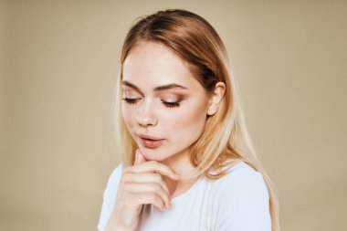 Güzel kadın beyaz tişörtlü eğlenceli duygular bej arka plan kırpılmış görünüm