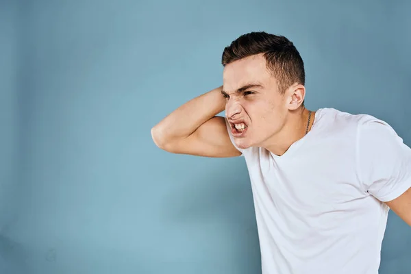 Man gebaart met zijn handen emoties wit t-shirt expressie blauw achtergrond — Stockfoto