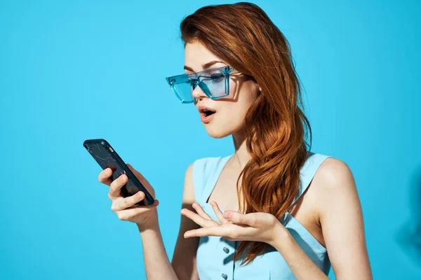 Bonita mujer en gafas azules con teléfono en las manos tecnología de comunicación aislado fondo —  Fotos de Stock