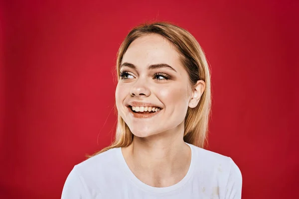 Mulher bonita sorriso branco t-shirt cortada ramos vermelho fundo — Fotografia de Stock