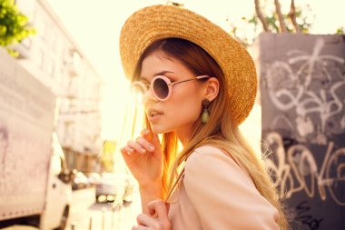 Zarif bir kadın, güneşli bir günde şehir tarzı yürür.