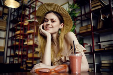 Kafede meyve suyu içen şapkalı güzel bir kadın.