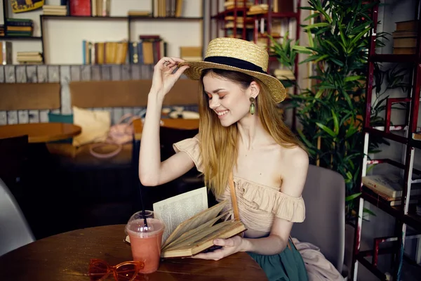 Frau sitzt in einem Café am Tisch und liest Buch — Stockfoto