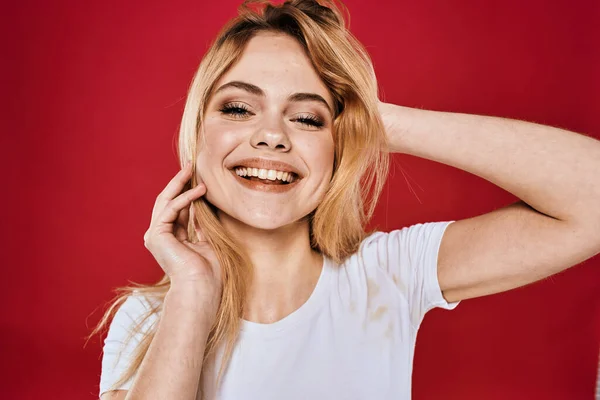 Mulher bonita sorriso branco t-shirt cortada ramos vermelho fundo — Fotografia de Stock