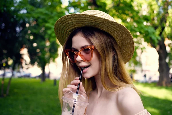 Bella donna in un cappello nel parco all'aperto vetro con un drink Giornata estiva — Foto Stock