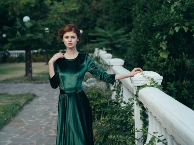 Güzel, çekici, yeşil elbiseli, zarif, doğa şatafatlı kadın.