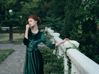 Güzel, çekici, yeşil elbiseli, zarif, doğa şatafatlı kadın.