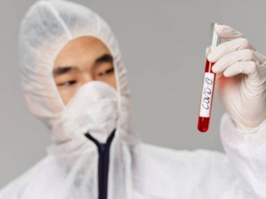 Erkek laboratuvar teknisyeni covid-19 teknoloji araştırmasını analiz ediyor.