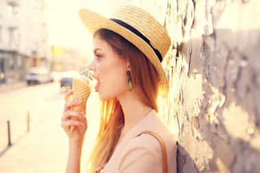 Sokakta elinde dondurma şapkası olan güzel bir kadın şehirde dolaşıyor.