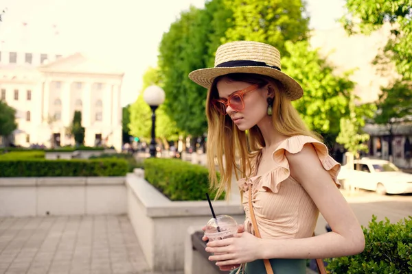 Mujer elegante en vasos y un sombrero de cristal con una bebida al aire libre en verano — Foto de Stock