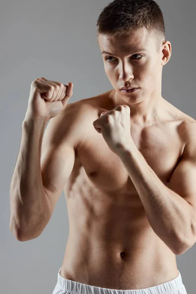 Boxer napumpoval sval pěst šedé pozadí cvičení oříznutý pohled — Stock fotografie