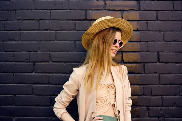Elegante donna in occhiali da sole su una strada a piedi stile urbano mattone sfondo — Foto Stock