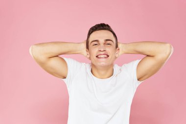 Beyaz tişörtlü neşeli yakışıklı adam duygular pembe soyutlanmış arka plan