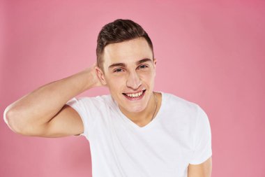 Beyaz tişörtlü bir adam elleri ve duyguları ile jestler yapıyor.