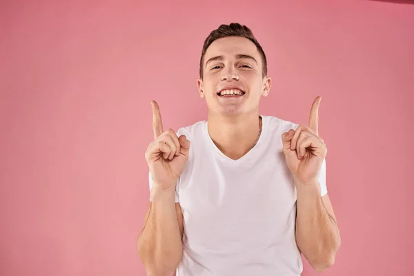 하얀 티셔츠를 입고 핑크 색 배경 스튜디오에서 웃음을 짓는 명랑 한 남자 — 스톡 사진