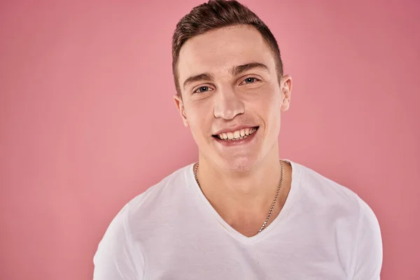 Vrolijk man in wit t-shirt glimlach emoties close-up roze achtergrond studio — Stockfoto