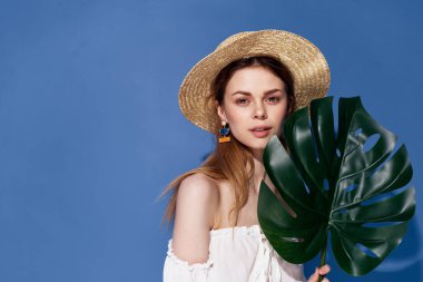 Şapkalı kadın ellerinde lüks egzotik mavi arka plan