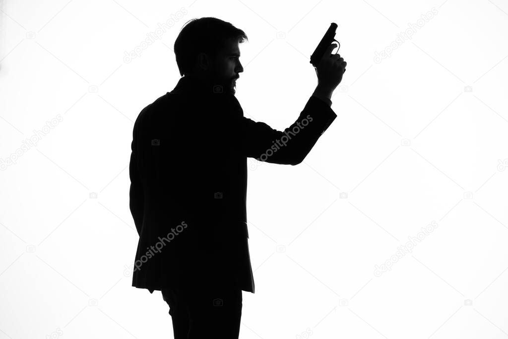 shadow of a man with a gun in his hands aiming suicide danger