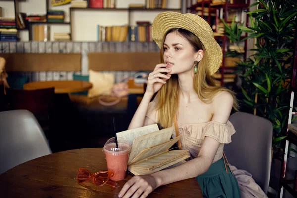 戴帽子的女人坐在咖啡厅里喝着安眠药 — 图库照片