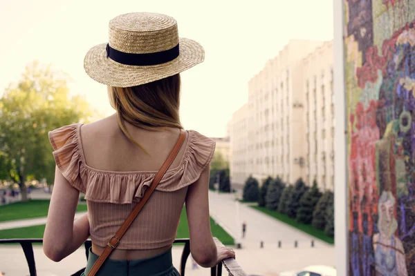 Şapkalı güzel bir kadın yaz parkında gezer.