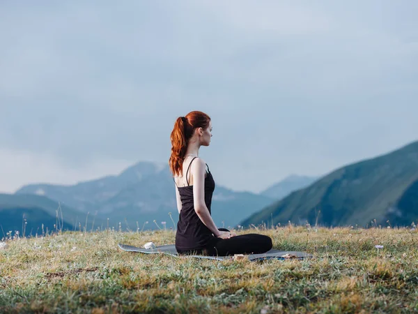 İnce bir kadın yogayla meşgul. Dağlarda tayt ve tişörtle. — Stok fotoğraf