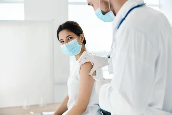 医療用マスクの女性と注射器の予防接種感染症の医師 — ストック写真