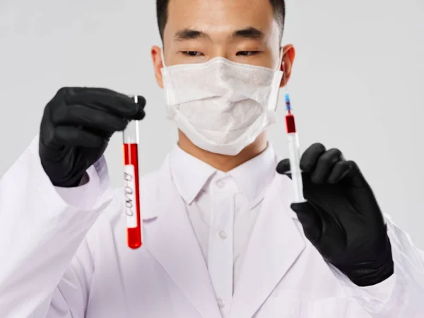 Чоловіча лабораторія асистент медичної маски аналізує дослідження діагностики сірого фону — стокове фото