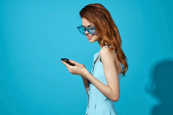 Bonita mujer en gafas azules con teléfono en las manos tecnología de comunicación aislado fondo — Foto de Stock