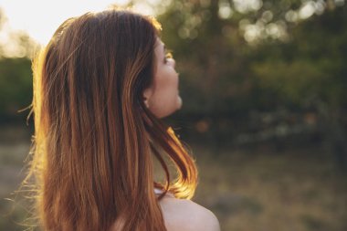 Dışarıda bahçede çekici bir kadın gün batımı taze hava ağaçları