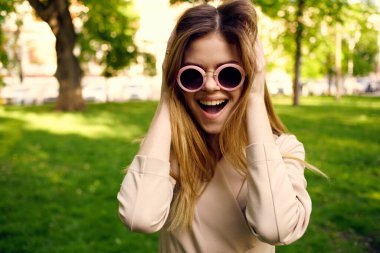 Siyah yuvarlak gözlüklü güzel bir kadın ve parkta yaz tatili.