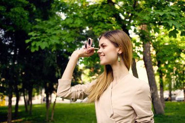 Yeşil ağaçların arasında güzel bir kadın dinleniyor.