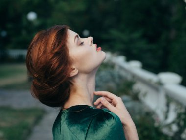 Yeşil elbiseli güzel bir kadın. Çekici görünüyor.