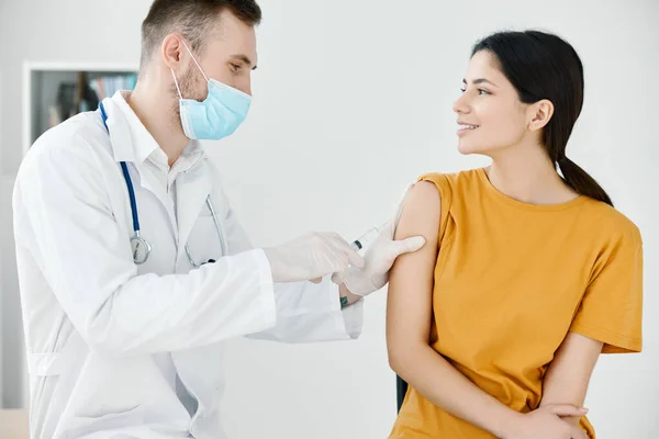 Opiekuńczy lekarz w rękawiczkach ochronnych w celu naklejenia wstrzyknięcia kobiecie szczepionki przeciw wiremii — Zdjęcie stockowe